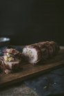 Stuffed pork tenderloin on wooden table with spices and ingredients — Stock Photo