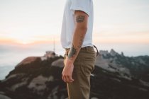 Handsome man with camera standing on cliff — Stock Photo