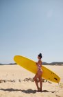 Pretty woman with surfboard on beach — Stock Photo