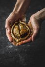 Human hands holding baked apple mini galette on black background — Stock Photo