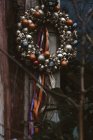 Corona de Navidad decorada con bolas de oro y rojo, colgando en el exterior de la casa - foto de stock