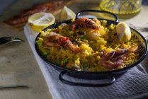 Paella marinera tradicional española con arroz, gambas, calamares y mejillones en sartén - foto de stock