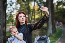 Madre prendendo selfie con allegra bambina nel parco — Foto stock