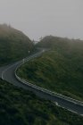 Estrada sinuosa vazia na colina — Fotografia de Stock