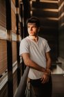 Nachdenklicher junger Mann steht im Gebäude im Sonnenlicht — Stockfoto