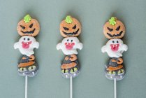 Bonbons d'Halloween sur bâtons sur fond coloré — Photo de stock