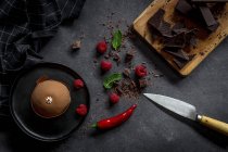 Chocolate with red raspberries, mint and cake on dark background — Stock Photo