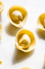 Primo piano dei tortellini crudi su un tavolo bianco — Foto stock