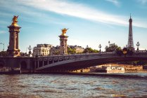 Великий річковий міст з ліхтарями під блакитним хмарним небом у Парижі. — стокове фото