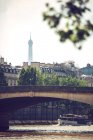 Мост через коричневую реку Сена в Париже на фоне городского пейзажа — стоковое фото