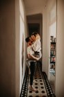 Homme et femme passionnés embrasser et embrasser au mur dans le hall à la maison — Photo de stock