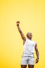 Funky happy man in glory with clenched fist on yellow background — Stock Photo