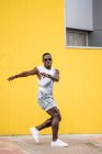 Afrikanisch-amerikanischer Mann im Jeansanzug übt Breakdance auf gelbem Hintergrund — Stockfoto