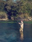Niño pescando en el río - foto de stock