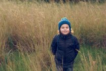 Fröhlicher kleiner Junge steht im Gras — Stockfoto