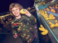 Junge fängt Ente auf Jahrmarkt — Stockfoto