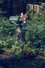 Kind gießt Pflanzen im Garten — Stockfoto