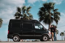 Couple embraced at van at seaside — Stock Photo