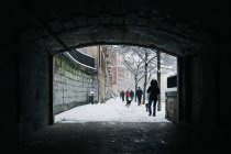 Люди ходят по белой улице зимой — стоковое фото