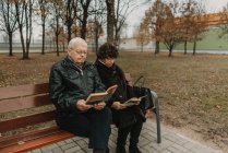 Coppia anziana lettura libri nel parco — Foto stock