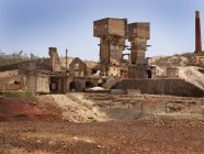 Edifício industrial resmungão no meio da mina de São Domingos no dia ensolarado em Portugal — Fotografia de Stock