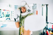 Pose im Fitnessstudio-Interieur mit Astronautenhelm .. — Stockfoto