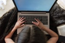 Невпізнавана дівчина використовує ноутбук на ковдрі — стокове фото