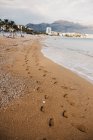 Сліди людських ніг на мокрому піску біля моря в Алті (Іспанія). — стокове фото