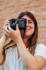 Chica joven posando con una cámara vintage - foto de stock
