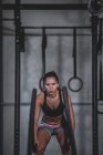 Femme faisant de l'exercice avec des cordes de combat dans une salle de sport — Photo de stock