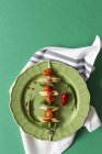 Macaroni with tomato and basil on stick on green background — Stock Photo