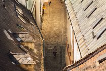 BRATISLAVA, ESLOVAQUIA, 30 DE SEPTIEMBRE DE 2016: Hombre caminando por la calle adoquinada del casco antiguo de Bratislava por la noche - foto de stock