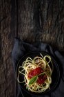 Spaghetti with tomato sauce and basil on plate on dark wooden background — Stock Photo