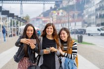Молоді усміхнені жінки беруть селфі на смартфон на прогулянці — стокове фото