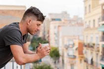 Расслабляющий мужчина пьет кофе на балконе — стоковое фото