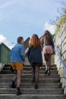 Back view stylish young ladies in casual wear going up stairs and blue sky in Porto, Portugal — Stock Photo