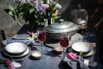 Установка скатерти с артишоками, цветами и красным вином — стоковое фото