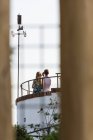 Visão traseira de casal irreconhecível em pé no telhado e tirar selfie com câmera fotográfica — Fotografia de Stock