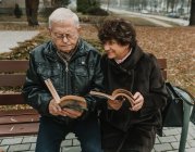 Seniorenpaar liest Bücher im Park — Stockfoto