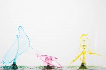 Closeup shot of splash of colorful transparent liquid on white background — Stock Photo