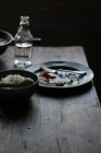 Bowl of rice and empty plate on rustic wooden table on dark background — Stock Photo