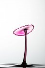 Nahaufnahme von Spritzer rosa transparenter Flüssigkeit auf weißem Hintergrund — Stockfoto