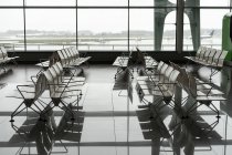 Grande sala de espera vazia no aeroporto com vista para aviões a partir de janelas no Porto, Portugal — Fotografia de Stock