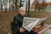 Älterer Mann liest Zeitung im Park — Stockfoto