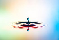 Closeup shot of splash of colorful transparent liquid on colorful background — Stock Photo