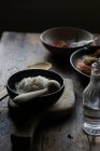 Bowl of rice on rustic wooden table on dark background — Stock Photo
