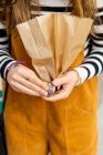 Crop young lady in sweater and jumpsuit holding craft packets in Porto, Portugal — Stock Photo