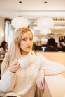 Jeune femme charmante tenant tasse dans un café — Photo de stock