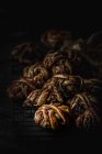 Monte de deliciosos pães de chocolate em grade de metal no fundo escuro — Fotografia de Stock