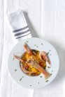 Hausgemachte Paella mit Krebsen und Garnelen auf Teller auf weißer Tischdecke serviert — Stockfoto